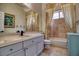 Well-lit bathroom with marble tile, shower over tub, and a large vanity mirror at 129 Chateau Whistler Ct, Las Vegas, NV 89148