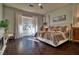 Inviting bedroom with dark wood floors, a cozy bed, and bright windows at 129 Chateau Whistler Ct, Las Vegas, NV 89148