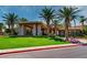 A welcoming clubhouse entrance features lush landscaping and stately stone columns, offering a luxurious community welcome at 129 Chateau Whistler Ct, Las Vegas, NV 89148