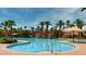 An expansive community pool is surrounded by palm trees and lounge chairs, offering residents a relaxing oasis at 129 Chateau Whistler Ct, Las Vegas, NV 89148