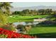 Scenic view of a lush golf course with a serene pond and mountain backdrop at 129 Chateau Whistler Ct, Las Vegas, NV 89148