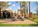 Inviting patio area with lounge chairs, a small table, and decorative palm trees at 129 Chateau Whistler Ct, Las Vegas, NV 89148