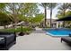 Beautiful backyard pool area with stylish lounge seating, lush landscaping, and a serene ambiance, perfect for relaxation at 1309 Reisling Ct, Las Vegas, NV 89144