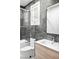 Contemporary bathroom with sleek fixtures, gray tile, glass shower enclosure, and a bright window at 1309 Reisling Ct, Las Vegas, NV 89144