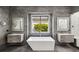 Modern main bathroom with dual vanities and a luxurious soaking tub with outside views at 1309 Reisling Ct, Las Vegas, NV 89144