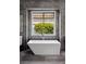 Bright main bathroom with a soaking tub set beneath a window showcasing vibrant outdoor scenery at 1309 Reisling Ct, Las Vegas, NV 89144