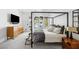 Spacious main bedroom with a four-poster bed, dresser, and serene backyard view at 1309 Reisling Ct, Las Vegas, NV 89144