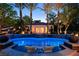 Relaxing pool area with illuminated water, lounge chairs, and palm trees for a resort-like experience at 1309 Reisling Ct, Las Vegas, NV 89144