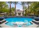 Luxurious pool area featuring palm trees, a cabana, and in-water lounge chairs at 1309 Reisling Ct, Las Vegas, NV 89144