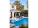 Relax in the pool with tanning ledge, luxurious lounge chairs, and an outdoor seating area shaded by a pergola at 1309 Reisling Ct, Las Vegas, NV 89144