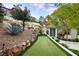 Lush green putting green is beautifully landscaped with rock features, plants, and a hillside backdrop at 1309 Reisling Ct, Las Vegas, NV 89144