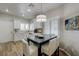 Eat-in kitchen with sleek, modern lighting and a dark wood table with bright white chairs at 1372 Couperin Dr, Henderson, NV 89052
