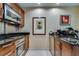 Efficient kitchenette with stainless steel appliances, dark countertops, and wooden cabinets, perfect for quick meal preparation at 145 E Harmon Ave # 3101, Las Vegas, NV 89109