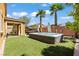 Landscaped backyard featuring multiple spas, covered patio, mature palms, and artificial grass at 1776 Gentle Brook St, North Las Vegas, NV 89084