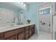Bright bathroom with double sinks, wooden cabinets, and a separate bathtub with shower at 1776 Gentle Brook St, North Las Vegas, NV 89084