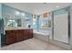 Bathroom featuring double sink vanity, bathtub, and glass enclosed shower at 1776 Gentle Brook St, North Las Vegas, NV 89084