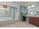 Well-lit bathroom with a bathtub and shower combo, vanity and tiled floors at 1776 Gentle Brook St, North Las Vegas, NV 89084