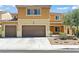Two-story home with a three-car garage, desert landscaping, and a tan and brown color palette at 1776 Gentle Brook St, North Las Vegas, NV 89084