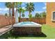 Relax in this backyard hot tub featuring a stone surround and surrounded by swaying palm trees at 1776 Gentle Brook St, North Las Vegas, NV 89084