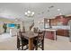 Open-concept kitchen and dining area featuring dark wood cabinets, stainless steel appliances, and a spacious island at 1776 Gentle Brook St, North Las Vegas, NV 89084