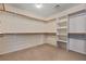Organized walk-in closet with shelving and wooden rods for ample storage at 1776 Gentle Brook St, North Las Vegas, NV 89084