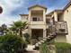 Multi-level exterior of a stucco condo building with stairs, balconies, and desert landscaping at 1830 N Buffalo Dr # 2098, Las Vegas, NV 89128