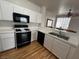 Kitchen featuring white cabinets, laminate countertops, and black appliances at 1830 N Buffalo Dr # 2098, Las Vegas, NV 89128