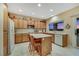 Bright kitchen featuring wood cabinets, island, tile flooring, and access to the backyard at 1960 Oliver Springs St, Henderson, NV 89052