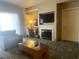 Comfortable living room featuring fireplace, TV, sofa, and writing desk with natural light at 211 E Flamingo Rd # 1012, Las Vegas, NV 89169