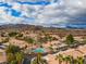 Expansive aerial view of a well-maintained community with desert landscaping and mountain views under a partly cloudy sky at 2219 Rugged Mesa Dr, Laughlin, NV 89029