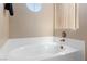 Bright bathroom features a garden tub with tile surround and round window at 2219 Rugged Mesa Dr, Laughlin, NV 89029