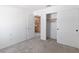 Bright bedroom featuring neutral walls, carpeted floors and closet with sliding doors, next to ensuite bathroom at 2219 Rugged Mesa Dr, Laughlin, NV 89029