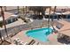 Community pool with lounge chairs, desert landscaping, and surrounding residential buildings at 2219 Rugged Mesa Dr, Laughlin, NV 89029