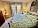 Bright bedroom with a comfortable bed, floral bedding, and large sliding glass doors to a private balcony at 2232 Aspen Mirror Dr # 203, Laughlin, NV 89029