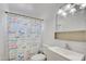 Bright bathroom showcasing a delightful shower curtain, white vanity, and ample mirror space at 304 Elliott Ave, Las Vegas, NV 89106