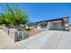 View of the front of this home with a large driveway and mature landscaping in a desert setting at 304 Elliott Ave, Las Vegas, NV 89106