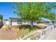 Exterior view of the home's front yard featuring mature trees, rock landscaping and white fence at 304 Elliott Ave, Las Vegas, NV 89106