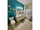 Bright bathroom featuring a teal accent wall, white vanity with vessel sink, and tiled floors at 3400 Cabana Dr # 1061, Las Vegas, NV 89122