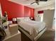 Primary bedroom featuring a large bed, ensuite bathroom, and red accent wall at 3400 Cabana Dr # 1061, Las Vegas, NV 89122