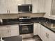 Modern kitchen featuring white cabinets, stainless steel appliances, and beautiful black countertops at 4128 Annie Oakley Dr, Las Vegas, NV 89121