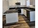 Well-appointed kitchen with white cabinetry, modern appliances, black countertop, and wood-look flooring at 4128 Annie Oakley Dr, Las Vegas, NV 89121