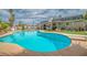 Lush backyard featuring a sparkling pool, well-manicured lawn, and mature trees at 4394 El Campana Way, Las Vegas, NV 89121
