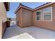 Enclosed back patio featuring a concrete floor and dark brown stucco exterior under a clear, blue sky at 5629 Portage Lake Ct, Las Vegas, NV 89130