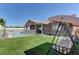 Well-maintained backyard with a pool, covered patio, manicured lawn, and comfortable seating, ideal for leisure at 5629 Portage Lake Ct, Las Vegas, NV 89130