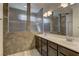 Well-lit bathroom with double sinks, tile flooring, and glass shower panel at 5629 Portage Lake Ct, Las Vegas, NV 89130
