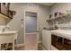 Functional laundry room equipped with a utility sink, storage cabinets, and modern washer and dryer at 5629 Portage Lake Ct, Las Vegas, NV 89130