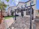 Backyard with a charming pergola-covered patio, stone pavers, and artificial turf at 5664 Dawn Falls St, Las Vegas, NV 89148
