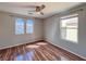 This bedroom features wood-look flooring, ceiling fan, and arched windows at 5664 Dawn Falls St, Las Vegas, NV 89148