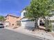 Two-story home showcasing a two-car garage, desert landscaping, and mature trees at 5664 Dawn Falls St, Las Vegas, NV 89148