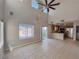 Spacious living room with tile flooring, large windows, and an adjacent kitchen at 5664 Dawn Falls St, Las Vegas, NV 89148